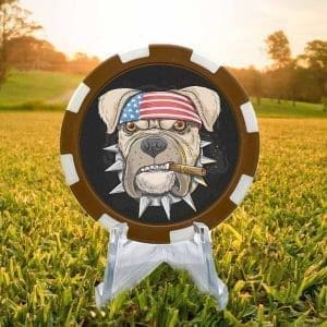 Brown and white golf ball marker poker chip featuring a rough and ready bulldog with spiked collar and cigar hanging from its mouth against a black background.